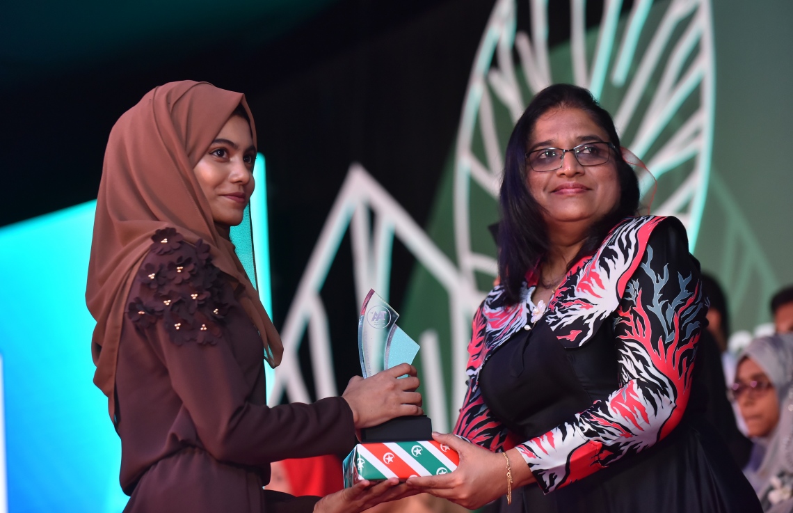 މާލެ: މާޗް 4، 2018- މިދިޔަ އަހަރުގެ އޭ ލެވެލް އިމްތިހާނުގެ ޓޮޕް އެޗީވާސް އެވޯޑް ދިނުމުގެ ރަސްމިއްޔާތުގައި، ރައީސް އޮފީހުގެ ލީގަލް އެފެއާޒް މިނިސްޓަރު އައިޝަތު އާޒިމާ ޝަކޫރު ދަރިވަރަކަށް އިނާމު ދެއްވަނީ---ފޮޓޯ: ހުސައިން ވަހީދު/މިހާރު