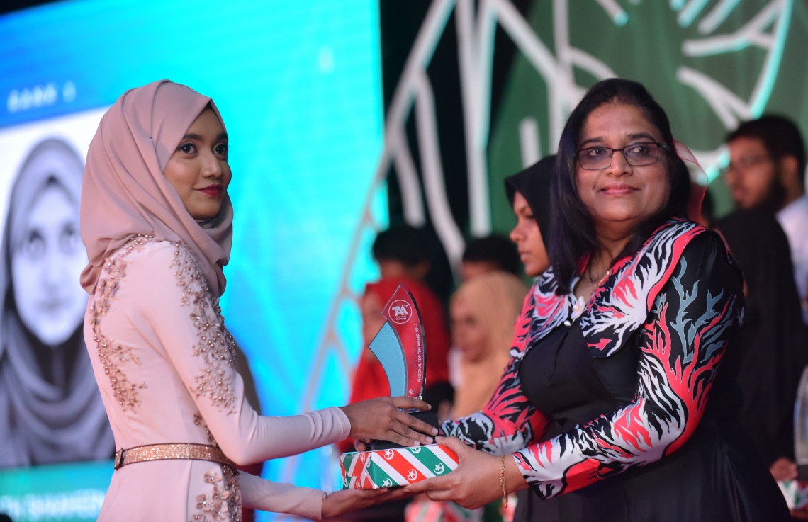 މާލެ: މާޗް 4، 2018- މިދިޔަ އަހަރުގެ އޭ ލެވެލް އިމްތިހާނުގެ ޓޮޕް އެޗީވާސް އެވޯޑް ދިނުމުގެ ރަސްމިއްޔާތުގައި، ރައީސް އޮފީހުގެ ލީގަލް އެފެއާޒް މިނިސްޓަރު އައިޝަތު އާޒިމާ ޝަކޫރު ދަރިވަރަކަށް އިނާމު ދެއްވަނީ---ފޮޓޯ: ހުސައިން ވަހީދު/މިހާރު