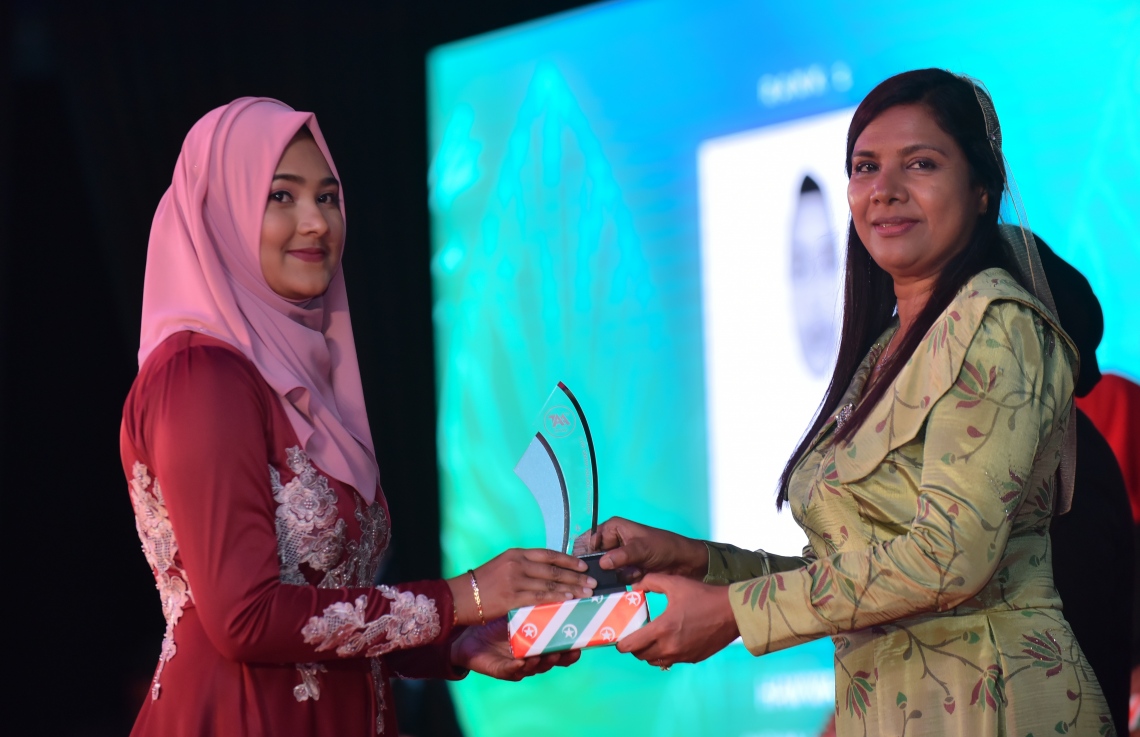 މާލެ: މާޗް 4، 2018- މިދިޔަ އަހަރުގެ އޭ ލެވެލް އިމްތިހާނުގެ ޓޮޕް އެޗީވާސް އެވޯޑް ދިނުމުގެ ރަސްމިއްޔާތުގައި އެޑިއުކޭޝަން މިނިސްޓަރު އައިޝަތު ޝިހާމް ދަރިވަރަކަށް އިނާމު ދެއްވަނީ---ފޮޓޯ: ހުސައިން ވަހީދު/މިހާރު