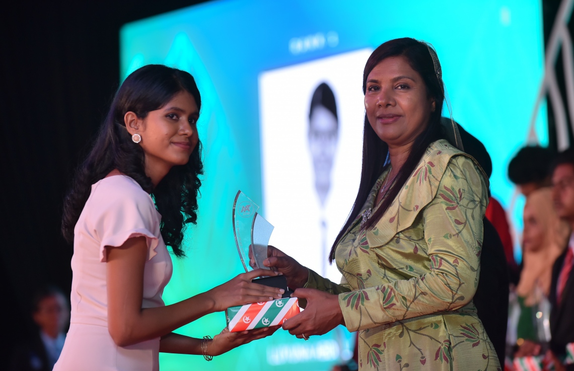 މާލެ: މާޗް 4، 2018- މިދިޔަ އަހަރުގެ އޭ ލެވެލް އިމްތިހާނުގެ ޓޮޕް އެޗީވާސް އެވޯޑް ދިނުމުގެ ރަސްމިއްޔާތުގައި އެޑިއުކޭޝަން މިނިސްޓަރު އައިޝަތު ޝިހާމް ދަރިވަރަކަށް އިނާމު ދެއްވަނީ---ފޮޓޯ: ހުސައިން ވަހީދު/މިހާރު