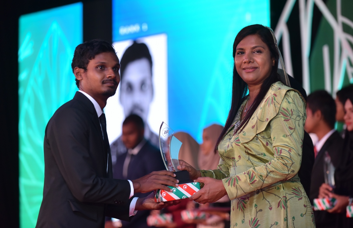 މާލެ: މާޗް 4، 2018- މިދިޔަ އަހަރުގެ އޭ ލެވެލް އިމްތިހާނުގެ ޓޮޕް އެޗީވާސް އެވޯޑް ދިނުމުގެ ރަސްމިއްޔާތުގައި އެޑިއުކޭޝަން މިނިސްޓަރު އައިޝަތު ޝިހާމް ދަރިވަރަކަށް އިނާމު ދެއްވަނީ---ފޮޓޯ: ހުސައިން ވަހީދު/މިހާރު