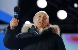 Presidential candidate, President Vladimir Putin addresses the crowd during a rally and a concert celebrating the fourth anniversary of Russia's annexation of Crimea at Manezhnaya Square in Moscow on March 18, 2018. / AFP PHOTO / POOL / Alexander Zemlianichenko