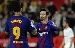 Barcelona's Argentinian forward Lionel Messi (R) celebrates a goal with Barcelona's Uruguayan forward Luis Suarez during the Spanish League football match between Sevilla FC and FC Barcelona at the Ramon Sanchez Pizjuan stadium on March 31, 2018. / AFP PHOTO / Cristina Quicler