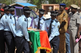 Burkina Faso's police officers carry a coffin on June 2, 2016 in Ouagadougou, during the funerals of three police officers killed on May 21, 2016 by unidentified gunmen in northern Burkina Faso near the Malian border. / AFP PHOTO