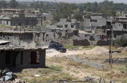 Iraqi government forces and elite counter-terrorism fighters patrol the outskirts of Fallujah's southern Shuhada neighbourhood during a military operation, backed by air support from the US-led coalition, to regain control of the area from the Islamic State (IS) group on June 13, 2016. Iraq's elite counterterrorism service moved to within three kilometres of central Fallujah and consolidated positions in the south of the city, the operation's commander Lieutenant General Abdelwahab al-Saadi said. / AFP PHOTO / AHMAD AL-RUBAYE
