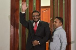 Former VP Adheeb waves as he is led out of the Criminal Court after he was sentenced to 10 years in prison on terror charges. MIHAARU PHOTO/ MOHAMED SHARUHAAN