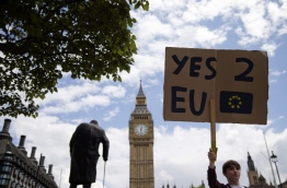 A demonstrator holds a placard during a protest against the outcome of the UK's June 23 referendum on the European Union (EU), in central London on June 25, 2016. The result of Britain's June 23 referendum vote to leave the European Union (EU) has pitted parents against children, cities against rural areas, north against south and university graduates against those with fewer qualifications. London, Scotland and Northern Ireland voted to remain in the EU but Wales and large swathes of England, particularly former industrial hubs in the north with many disaffected workers, backed a Brexit. / AFP PHOTO / JUSTIN TALLIS