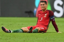 Portugal's forward Cristiano Ronaldo reacts as he sits on the pitch during the Euro 2016 final football match between France and Portugal at the Stade de France in Saint-Denis, north of Paris, on July 10, 2016. / AFP PHOTO / FRANCK FIFE