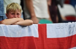 A young England fan reacts during after England lost 1-2 to Iceland in the Euro 2016 round of 16 football match between England and Iceland at the Allianz Riviera stadium in Nice on June 27, 2016. / AFP PHOTO / PAUL ELLIS