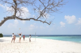 Tourists enjoy a game of beach volleyball at Malahini Kuda Bandos.