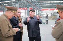This undated picture released from North Korea's official Korean Central News Agency (KCNA) on July 27, 2016 shows North Korean leader Kim Jong-Un (C) inspecting the Chollima building materials complex in Pyongyang. / AFP PHOTO / KCNA / KCNA / South Korea