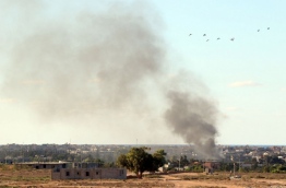 Smoke billows from buildings after the air force from the pro-government forces loyal to Libya's Government of National Unity (GNA) fired rockets targeting Islamic State (IS) group positions in Sirte on July 18, 2016, during an operation to recapture the jihadists' coastal stronghold. / AFP PHOTO / MAHMUD TURKIA