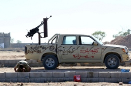 A fighter from the pro-government forces loyal to Libya's Government of National Unity (GNA) prays next to an armed vehicle on July 18, 2016 as they prepare to target Islamic State (IS) group positions in Sirte during an operation to recapture the jihadists' coastal stronghold. / AFP PHOTO / MAHMUD TURKIA