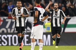 Juventus' Argentinian forward Gonzalo Higuain (R) celebrates after scoring during the Italian Serie A football match between Juventus and Cagliari on September 21, 2016 at Juventus Stadium in Turin. / AFP PHOTO / MARCO BERTORELLO