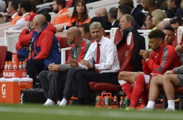 Arsenal's French manager Arsene Wenger (C) sits in the team dugout during the English Premier League football match between Arsenal and Chelsea at the Emirates Stadium in London on September 24, 2016. / AFP PHOTO / Ben STANSALL