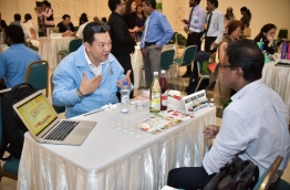 A representative of a Thailand export firm gives information on his company products to a Maldivian businessman at the forum held in Dharubaaruge. PHOTO: NISHAN ALI/MIHAARU
