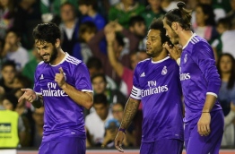 Real Madrid's midfielder Isco (L) celebrates after scoring past Real Madrid's Brazilian defender Marcelo (C) and Real Madrid's Welsh forward Gareth Bale during the Spanish league football match Real Betis vs Real Madrid CF at the Benito Villamarin stadium in Sevilla on October 15, 2016. / AFP PHOTO / CRISTINA QUICLER
