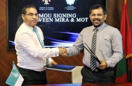 Tourism minister Moosa Zameer (R) and Commissioner General of Taxation Yazeed Mohamed shake hands after signing agreement. PHOTO/MIRA