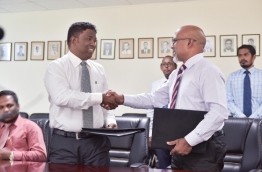 Education ministry’s permanent secretary Dr Abdul Muhsin Mohamed (R) and Qualitat Education’s managing director Moosa Rasheed sign and exchange agreement awarding the former Lale School building to Qualitat Education. PHOTO: MOHAMED SHARUHAAN/MIHAARU
