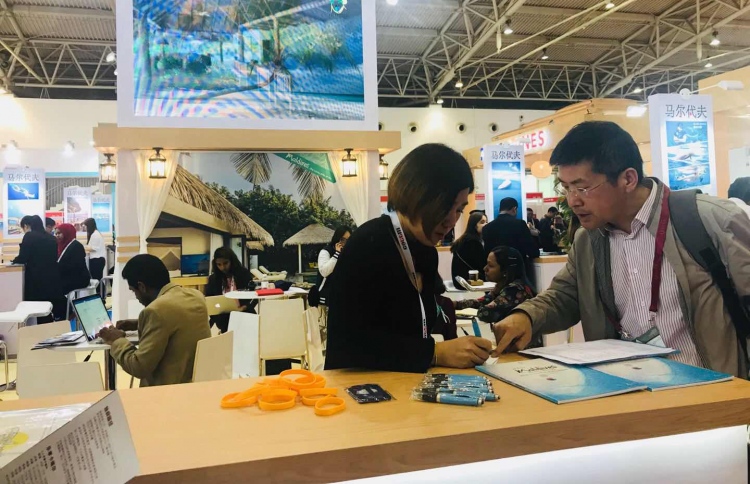 ޗައިނާ އައުޓްބައުންޑް ޓްރެވަލް އެންޑް ޓޫރިޒަމް މާކެޓްގައި ރާއްޖެ ޕްރޮމޯޓްކުރަން ހަދާފައިވާ ސްޓޭންޑްގައި މީހަކަށް ރާއްޖެއާ ބެހޭ މައުލޫމާތު ދެނީ. ފޮޓޯ: އެމްއެމްޕީއާރުސީ