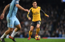 Arsenal's German midfielder Mesut Ozil runs with the ball during the English Premier League football match between Manchester City and Arsenal at the Etihad Stadium in Manchester, north west England, on December 18, 2016. / AFP PHOTO / Paul ELLIS / RESTRICTED TO EDITORIAL USE. No use with unauthorized audio, video, data, fixture lists, club/league logos or 'live' services. Online in-match use limited to 75 images, no video emulation. No use in betting, games or single club/league/player publications. /