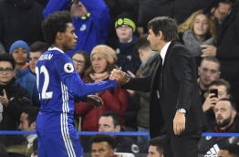 Chelsea's Italian head coach Antonio Conte (R) shakes hands with Chelsea's Brazilian midfielder Willian (L) during the English Premier League football match between Chelsea and Bournemouth at Stamford Bridge in London on December 26, 2016. / AFP PHOTO / Glyn KIRK / RESTRICTED TO EDITORIAL USE. No use with unauthorized audio, video, data, fixture lists, club/league logos or 'live' services. Online in-match use limited to 75 images, no video emulation. No use in betting, games or single club/league/player publications. /