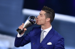 Real Madrid and Portugal's forward Cristiano Ronaldo kisses his trophy after winning the The Best FIFA Mens Player of 2016 Award next to FIFA president Gianni Infantino during The Best FIFA Football Awards ceremony, on January 9, 2017 in Zurich. / AFP PHOTO / Fabrice COFFRINI