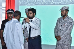 Home Minister Azleen awards a medal to a Maafushi Prison inmate for completing a course conducted by the Institute for Correctional Services. PHOTO: NISHAN ALI/MIHAARU