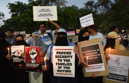This photo taken on April 16, 2018 shows protesters taking part in a candlelight vigil in Ahmedabad, in support of rape victims following high profile cases in Jammu and Uttar Pradesh state.
Eight men accused of raping and murdering an eight-year-old girl pleaded not guilty on April 16 to the horrific crime that has sparked revulsion and brought thousands to India's streets in protest.
 / AFP PHOTO / SAM PANTHAKY