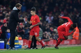 Liverpool's Brazilian midfielder Philippe Coutinho (C) shakes hands with Liverpool's German manager Jurgen Klopp after being substituted off for Liverpool's Dutch midfielder Georginio Wijnaldum during the EFL (English Football League) Cup semi-final second-leg football match between Liverpool and Southampton at Anfield in Liverpool, north west England on January 25, 2017. / AFP PHOTO / Paul ELLIS / RESTRICTED TO EDITORIAL USE. No use with unauthorized audio, video, data, fixture lists, club/league logos or 'live' services. Online in-match use limited to 75 images, no video emulation. No use in betting, games or single club/league/player publications. /