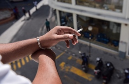 A person pictured holding a lit cigarette. MIHAARU FILE PHOTO