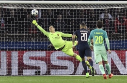 Barcelona's German goalkeeper Marc-Andre Ter Stegen (C) tries to stop the ball during the UEFA Champions League round of 16 first leg football match between Paris Saint-Germain and FC Barcelona on February 14, 2017 at the Parc des Princes stadium in Paris. / AFP PHOTO / PHILIPPE LOPEZ