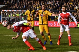 Arsenal's English defender Rob Holding (L) gets his head to the ball during the English FA Cup fifth round football match between Sutton United and Arsenal at the Borough Sports Ground, Gander Green Lane in south London on February 20, 2017. / AFP PHOTO / Glyn KIRK / RESTRICTED TO EDITORIAL USE. No use with unauthorized audio, video, data, fixture lists, club/league logos or 'live' services. Online in-match use limited to 75 images, no video emulation. No use in betting, games or single club/league/player publications. /