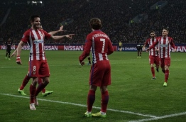 Atletico Madrid's French forward Antoine Griezmann and his teammates celebrate after scoring during the UEFA Champions League round of 16 first-leg football match between Bayer 04 Leverkusen and Club Atletico de Madrid in Leverkusen, western Germany on February 21, 2017. / AFP PHOTO / PATRIK STOLLARZ