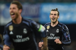 Real Madrid's Welsh forward Gareth Bale (R) smiles as Real Madrid's defender Sergio Ramos celebrates after scoring during the UEFA Champions League football match SSC Napoli vs Real Madrid on March 7, 2017 at the San Paolo stadium in Naples. Real Madrid won 1-3. / AFP PHOTO / Filippo MONTEFORTE