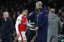 Arsenal's French manager Arsene Wenger (R) greets Arsenal's Chilean striker Alexis Sanchez after he is substituted during the UEFA Champions League last 16 second leg football match between Arsenal and Bayern Munich at The Emirates Stadium in London on March 7, 2017. / AFP PHOTO / IKIMAGES / Ian KINGTON