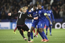 Leicester City's Nigerian midfielder Wilfred Ndidi (C), Leicester City's English-born Jamaican defender Wes Morgan (R) and Leicester City's Danish goalkeeper Kasper Schmeichel (L) celebrate their victory at the final whistle during the UEFA Champions League round of 16 second leg football match between Leicester City and Sevilla at the King Power Stadium on March 14, 2017. / AFP PHOTO / Oli SCARFF