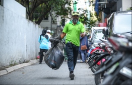An employee of WAMCO collecting waste-- Photo: Mihaaru