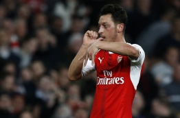 Arsenal's German midfielder Mesut Ozil celebrates after scoring the opening goal of the English Premier League football match between Arsenal and West Ham United at the Emirates Stadium in London on April 5, 2017. / AFP PHOTO / Ian KINGTON / RESTRICTED TO EDITORIAL USE. No use with unauthorized audio, video, data, fixture lists, club/league logos or 'live' services. Online in-match use limited to 75 images, no video emulation. No use in betting, games or single club/league/player publications. /