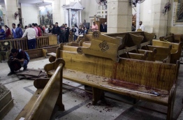 EDITORS NOTE: Graphic content / A picture taken on April 9, 2017 shows a general view of the destruction, debris, and blood stains on the benches of the Mar Girgis Coptic Orthodox Church in the Nile Delta City of Tanta, 120 kilometres (75 miles) north of Cairo, at which a bomb blast struck worshippers gathering to attend the Palm Sunday mass. / AFP PHOTO / STRINGER