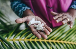 Woman holds out coral stones used for sugar-refining process to make Dhiyaa Hakuru. PHOTO/AISHATH NAJ