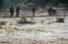 The death toll from heavy rains and flooding in southern Japan has risen to 15, a government official, as rescuers continued work to evacuate isolated survivors. / AFP PHOTO / JIJI PRESS / STR / Japan OUT
