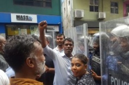 Police officers in riot gear and shields hold off crowds of people gathered over the parliament lockup. PHOTO/MIHAARU