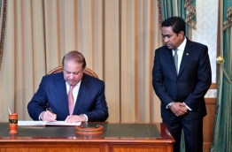 Pakistani PM Nawaz Sharif (L) signs guest book at the President's Office while President Abdulla Yameen looks on, PHOTO/PRESIDENT'S OFFICE