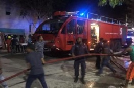 MNDF officers and people working together to put out a fire in a warehouse building in Hulhumale. PHOTO/MIHAARU