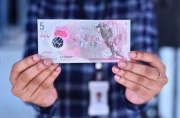 An MMA official holds up a cash note of the new polymer MVR 5.