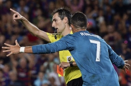 Real Madrid's Portuguese forward Cristiano Ronaldo (R) gestures after receiving a red card by referee Ricardo de Burgos Bengoetxea during the first leg of the Spanish Supercup football match between FC Barcelona and Real Madrid CF at the Camp Nou stadium in Barcelona on August 13, 2017. / AFP PHOTO / Josep LAGO
