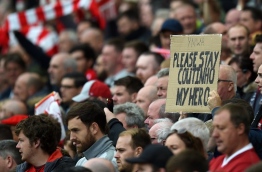 A fan holds up a placard in support of Liverpool's Brazilian midfielder Philippe Coutinho during the English Premier League football match between Liverpool and Crystal Palace at Anfield in Liverpool, north west England on August 19, 2017. / AFP PHOTO / Oli SCARFF / RESTRICTED TO EDITORIAL USE. No use with unauthorized audio, video, data, fixture lists, club/league logos or 'live' services. Online in-match use limited to 75 images, no video emulation. No use in betting, games or single club/league/player publications. /