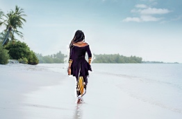 Girl in traditional dress walking along the beach in Hankede, Addu atoll. IMAGE/AISHATH NAJ
