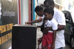 A boy puts money in a fund box placed by Raajje TV to raise aid for the persecuted Rohingya Muslims of Myanmar. PHOTO/TWITTER